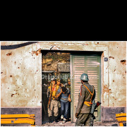 Vukovar (Croatia) – November 18, 1991

Serbian soldiers and volunteers escort a captured Croatian civilian from a basement shelter in the aftermath of the fighting in Vukovar.
The man is led through a doorway of a heavily damaged building marked by bullet impacts and shrapnel scars, while armed personnel secure the surroundings.

The photograph documents a tense moment following the collapse of organized resistance in the city, reflecting the realities of urban warfare and the treatment of detainees during the final phase of the siege of Vukovar.