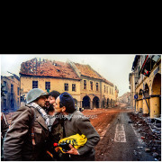 Vukovar (Croatia) – November 18, 1991

Three Serbian soldiers share a brief moment of intimacy and camaraderie on a devastated street in Vukovar, shortly after the fighting subsided.
Surrounded by heavily damaged buildings, bullet-scarred facades, and debris, the soldiers stand in the middle of an emptied city, momentarily removed from the violence that preceded the fall of Vukovar.

The photograph captures a rare, human moment amid the ruins of urban warfare, highlighting the contrast between personal interaction and the extensive destruction of the civilian environment.