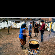 Villagers in Prekale, Kosovo and Metohija, prepare food while armed men stand guard in the background. The photograph reflects everyday life under constant fear during the political crisis following the abolition of Kosovo’s autonomy in late 1988.